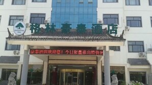 Um hotel com estilo arquitetônico tradicional chinês, apresentando uma fachada de vidro azul marcante e um logotipo verde.