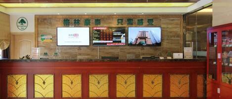 A reception desk with a digital display, a sign with Chinese characters, and a glass display case.