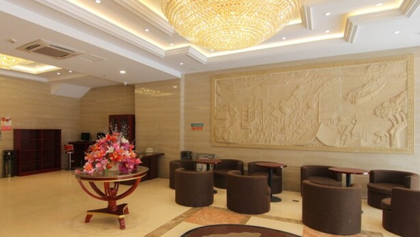 A lobby with a chandelier, a reception desk, and a wall mural. - GreenTree Inn JiangSu ZHenjiang Jurong Yalong Hotel (Zhenjiang)