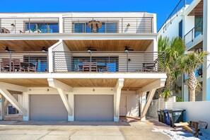 A multi-level building with a garage, balconies, and a palm tree. - Fanta-Sea on the Beach by Beachside Management - 55 Beach Rd (Siesta Key)