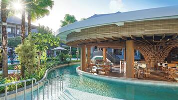 Una piscina al aire libre, sombrillas, sillones reclinables de piscina