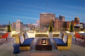 A rooftop lounge with outdoor seating, potted plants, and a city skyline view. - SpringHill Suites by Marriott New Orleans Downtown/Canal Street (New Orleans)