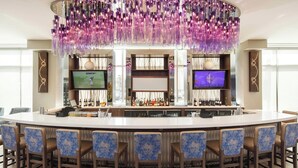 A bar area with a large island, bar stools, and a television screen. - SpringHill Suites by Marriott New Orleans Downtown/Canal Street (New Orleans)