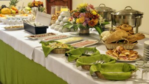 Un tavolo da buffet con diversi cibi, utensili e elementi decorativi.