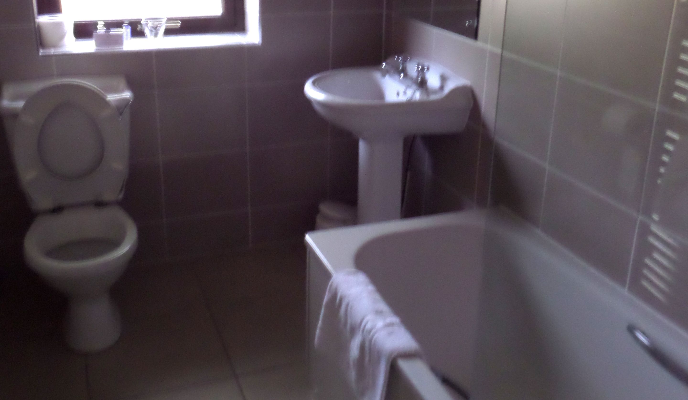 A bathroom with a toilet, sink, and bathtub.