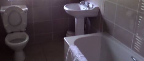 A bathroom with a toilet, sink, and bathtub.
