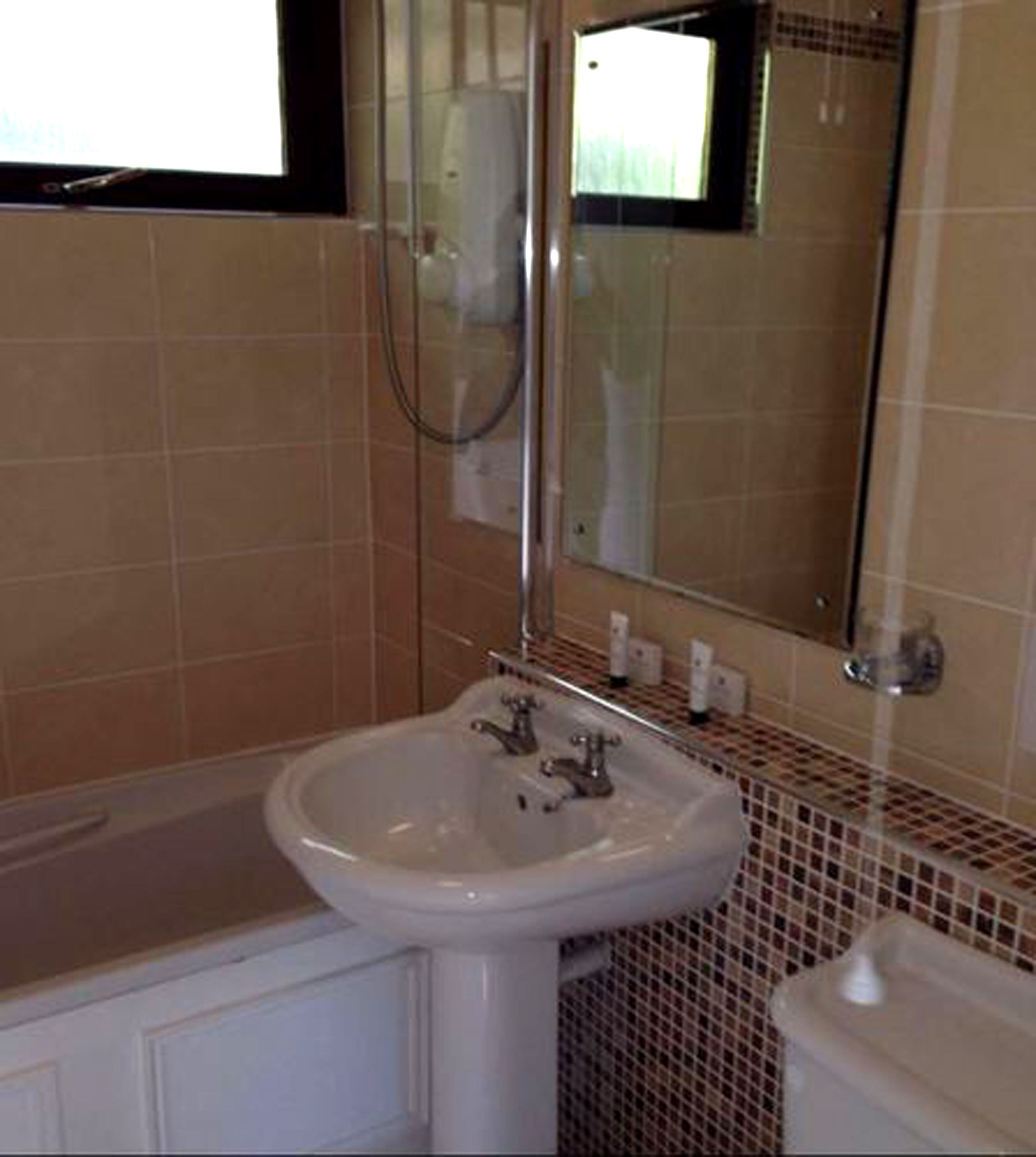 Ein Badezimmer mit Waschbecken, Spiegel und Dusche.