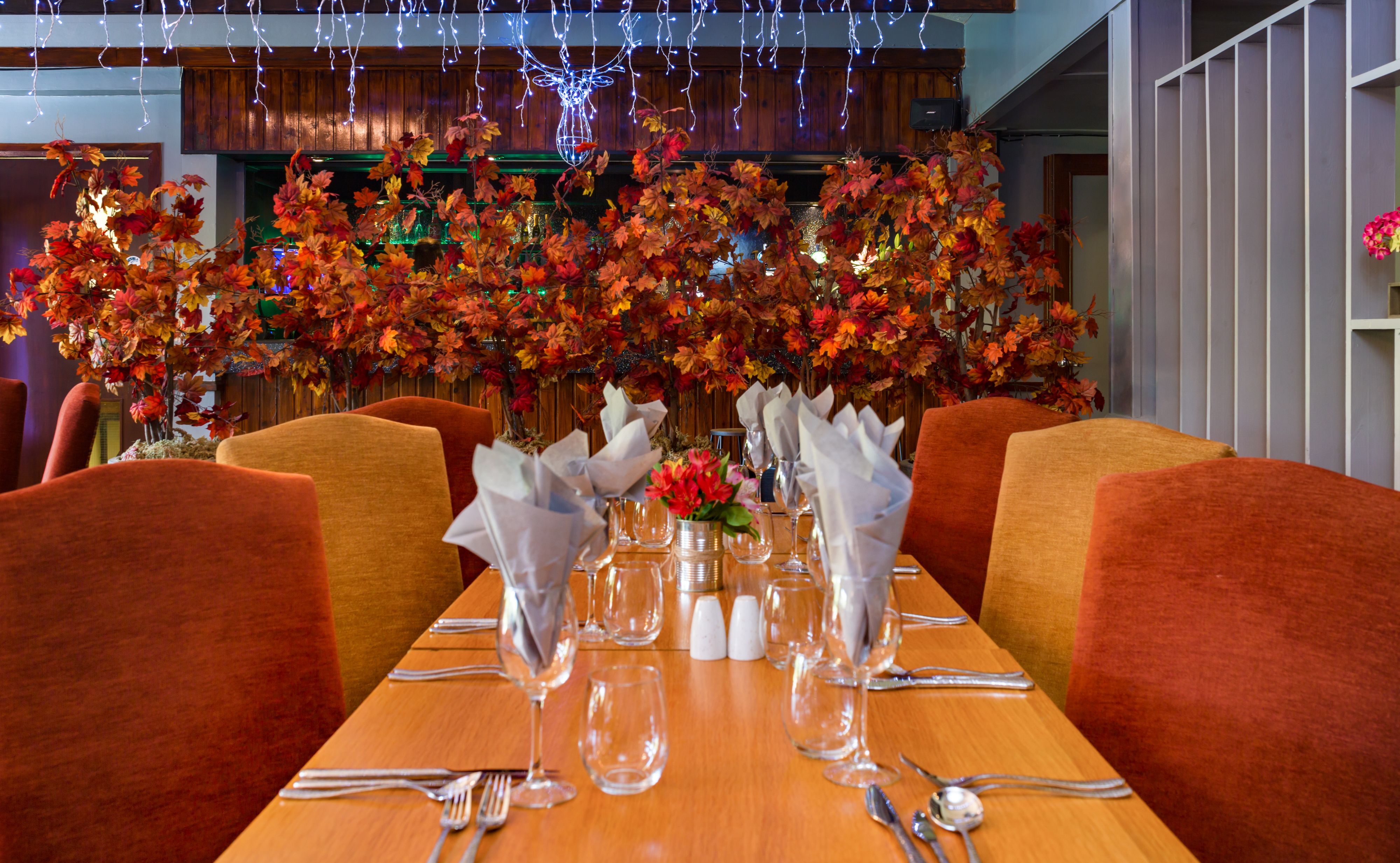 A dining table set with chairs, a vase with flowers, and salt and pepper shakers.