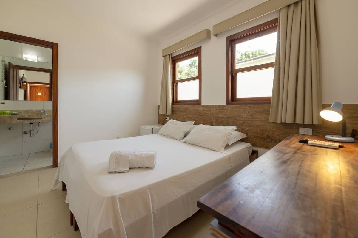 Une chambre d’hôtel avec un lit, une table de chevet, une lampe et une vue sur la salle de bain.