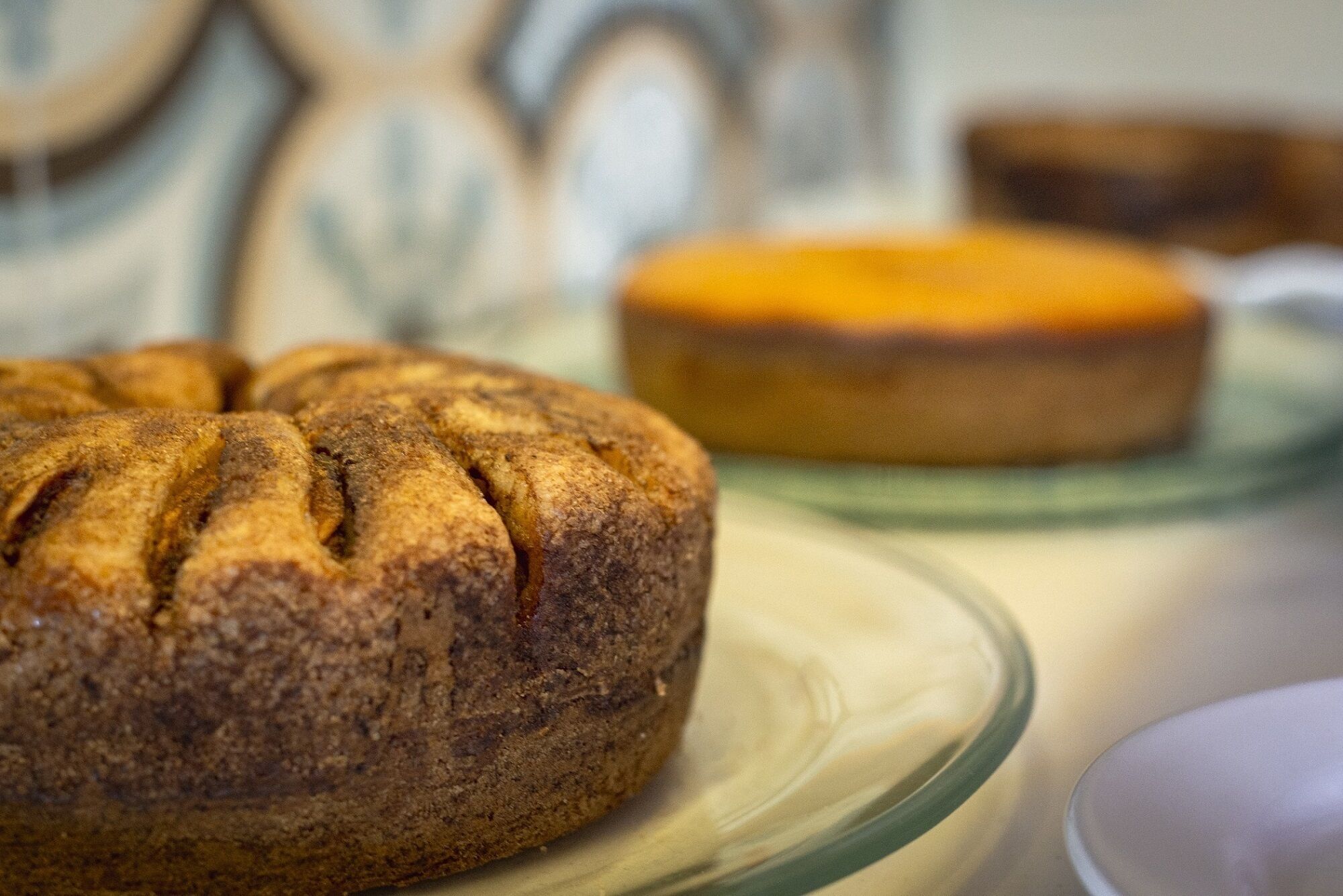 A round cake with a textured surface on a glass plate.