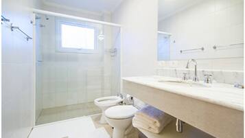 A modern bathroom with a shower, toilet, and sink.