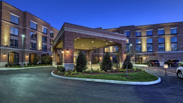 A multi-story hotel with a covered entrance, parking area, and landscaped garden. - Hampton Inn & Suites Franklin Berry Farms (Franklin)