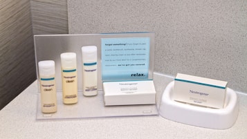 Un présentoir proposant des produits Neutrogena, notamment du shampooing, une lotion pour le corps et du savon, accompagné d’un panneau indiquant qu’il est possible d’obtenir gratuitement des produits de remplacement pour les articles oubliés.