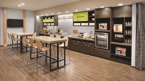 Una cocina moderna con comedor, equipada con microondas, cafetera y varios electrodomésticos.