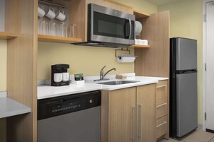 Una cocina moderna equipada con lavavajillas, microondas, refrigerador y fregadero.