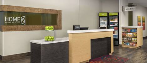 A hotel reception area with a reception desk, a minibar, and a snack bar.