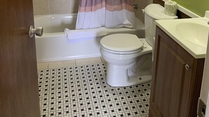 A bathroom with a bathtub, toilet, and sink.