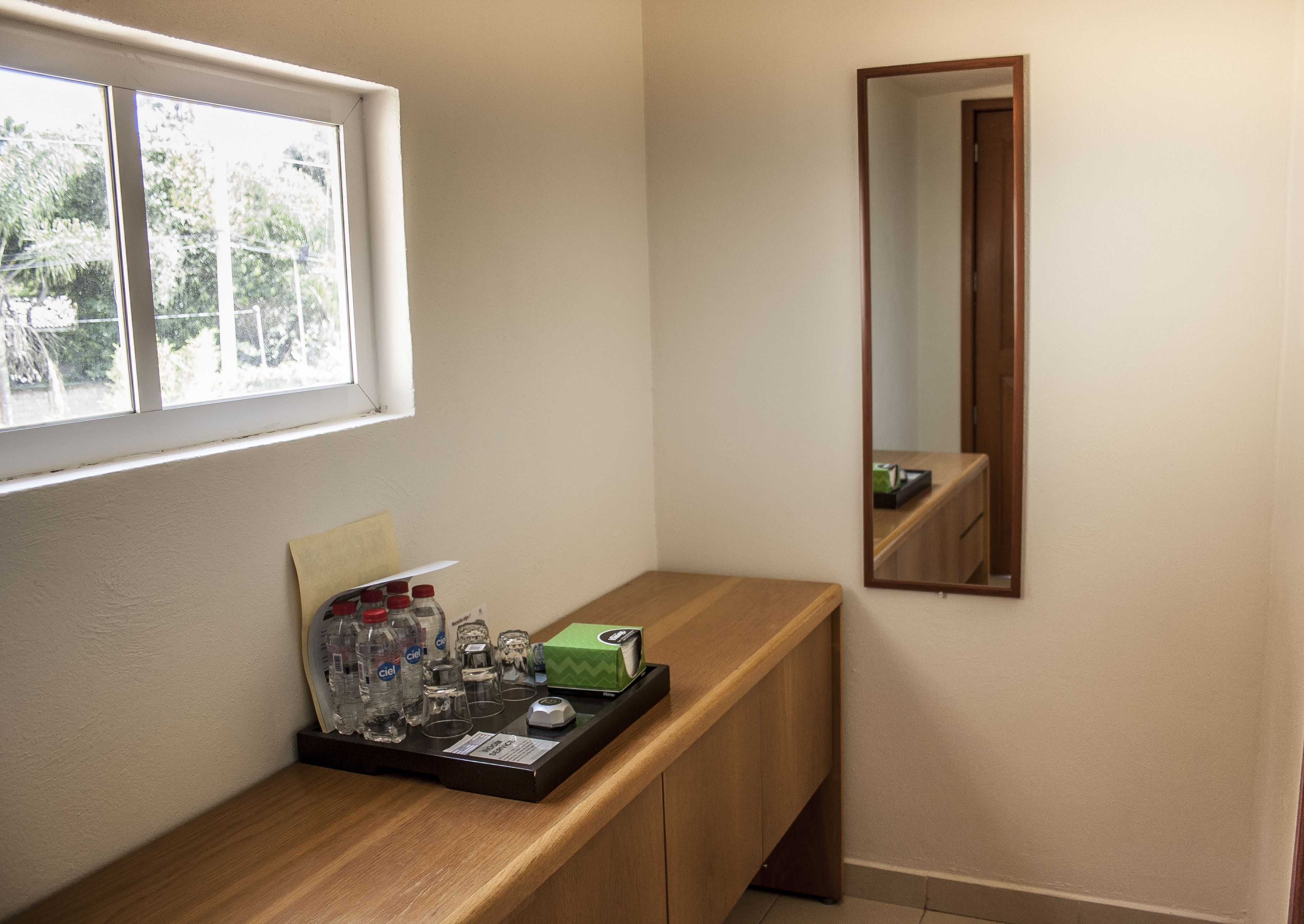 Un baño con tocador de madera, un espejo y una ventana.