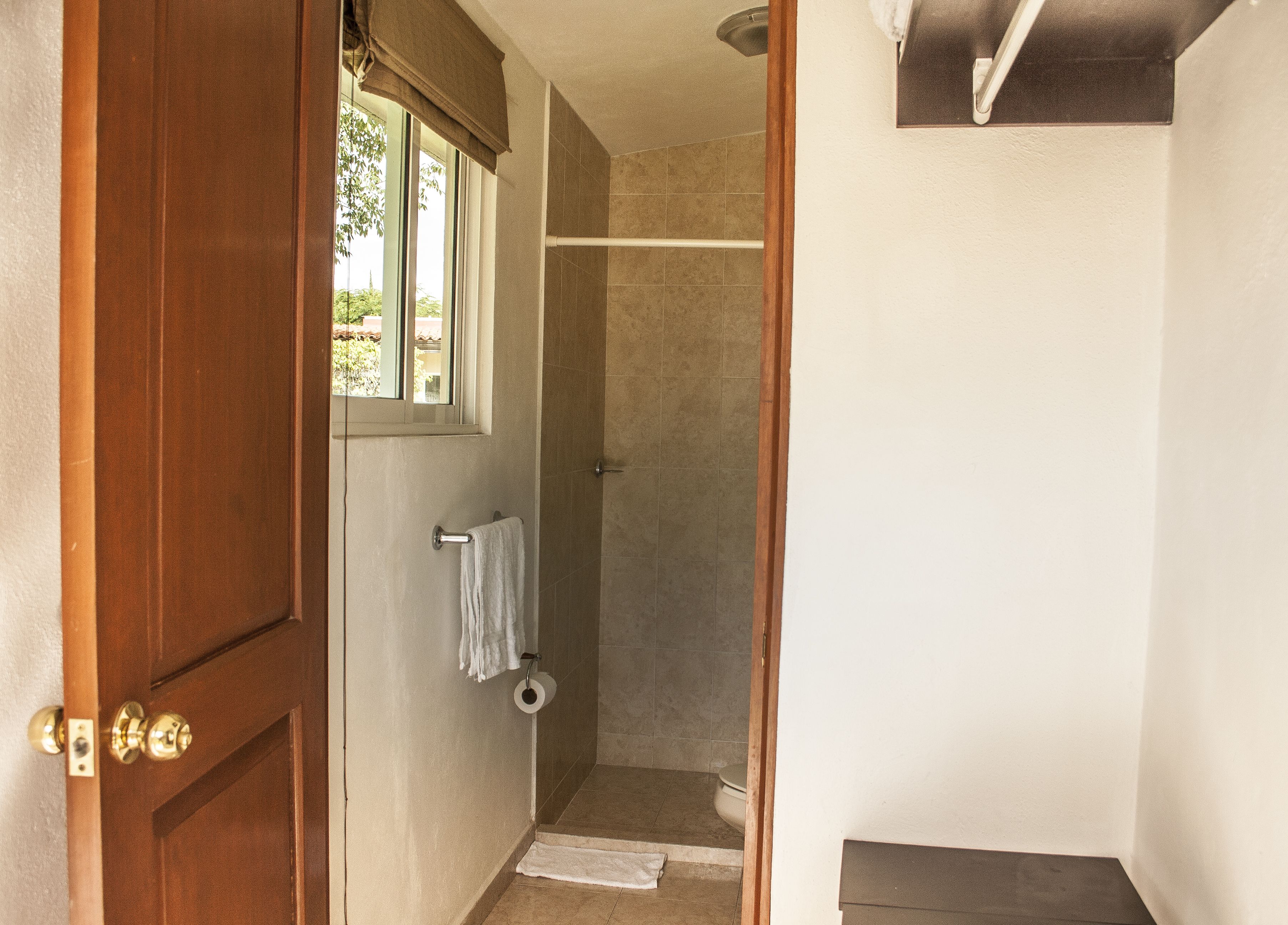 Een badkamer met een douche, toilet en een handdoek aan de muur.