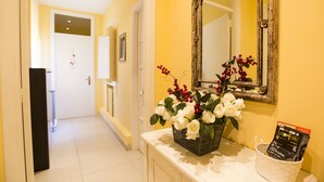 A hallway with a white door, a white wall, and a mirror with a decorative frame. - B&B Monica's House (Salerno)