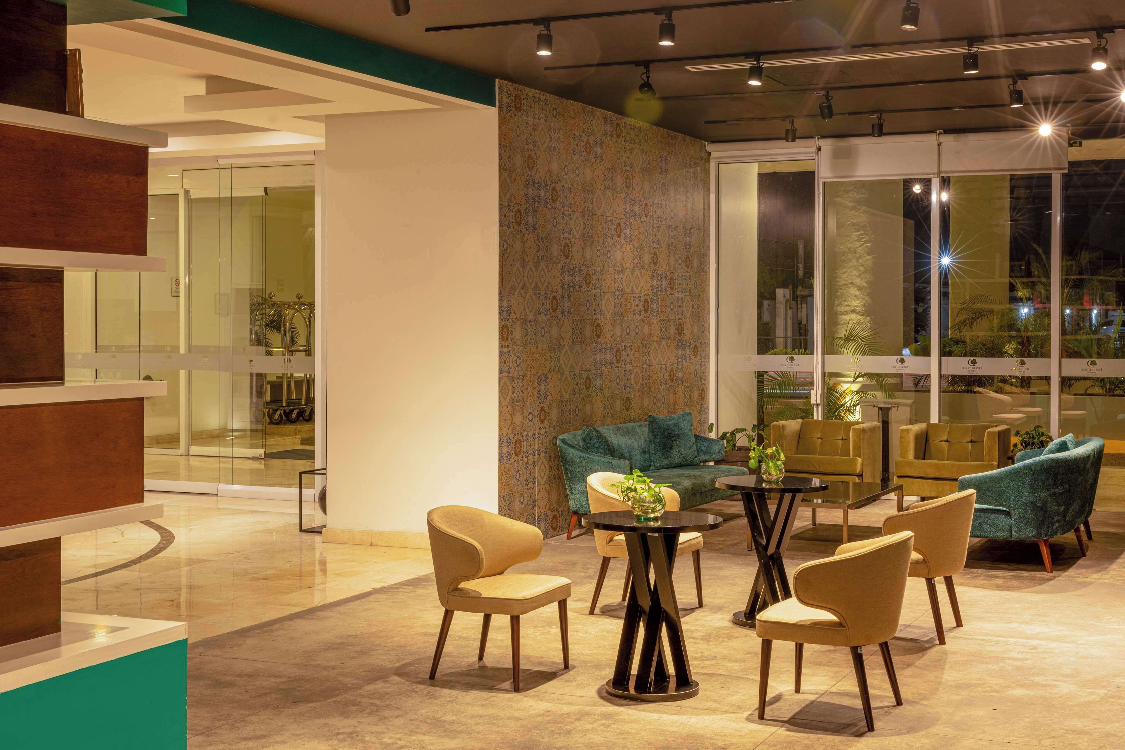 Un espace de détente moderne avec un mur en verre, des sièges confortables et un mur décoré de motifs.