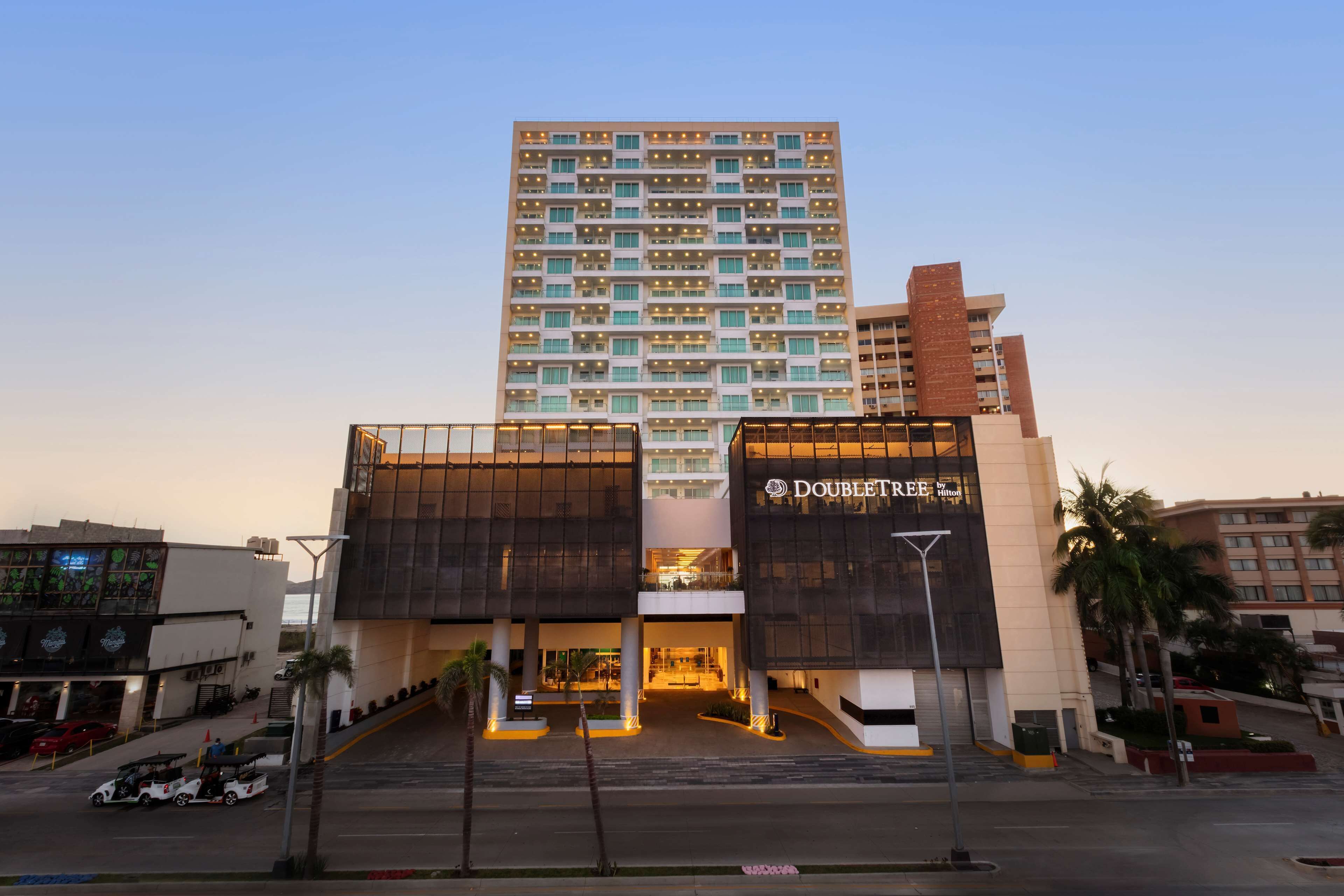 A hotel with a modern design, featuring a prominent entrance and multiple floors.
