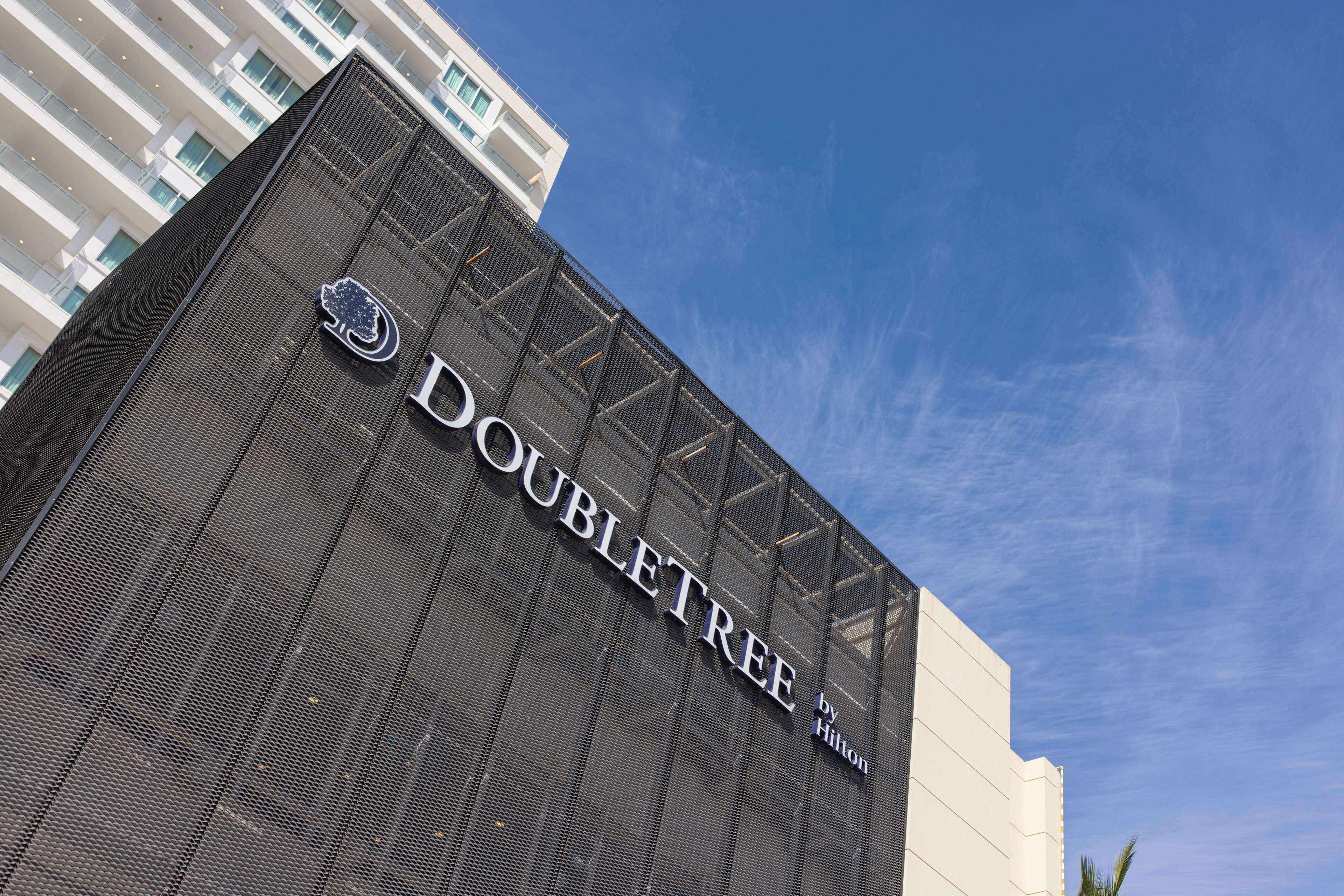 Un bâtiment portant l’enseigne « DOUBLETREE by Hilton », ce qui indique qu’il s’agit d’un hôtel de la chaîne Hilton.