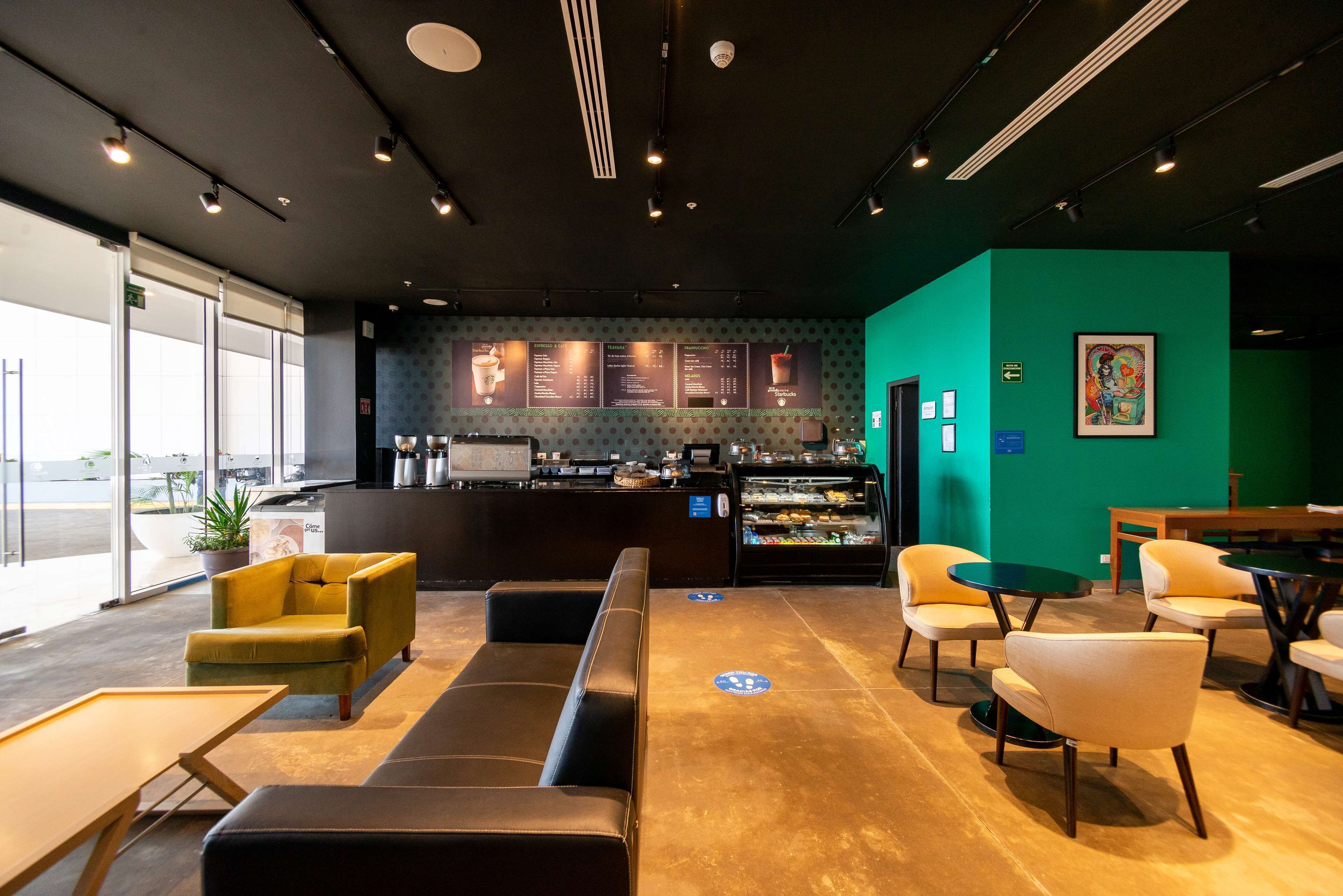 A modern cafe interior with seating, a counter, and a menu board.