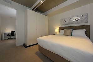 A hotel room with a large bed, a desk, and a wardrobe. - Accommodate Canberra - Dockside (Kingston)