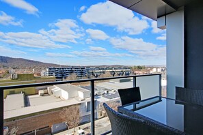 Ein Balkon mit freiem Blick auf einen Parkplatz und Gebäude in der Ferne.