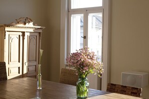 Et spisebord med en vase med blomster og en høj vase med en enkelt blomst.