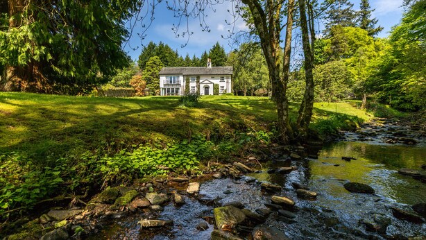 A house with a well-maintained lawn and a stream in front. - Magnificent Family House with Stunning Private Garden (Drymen)