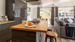 A modern kitchen with a central island, dark cabinetry, and a view to the outdoors. - Stunning Lodge set in relaxing surrounding, sleeps 6/8, 3 en-suites, free WIFI (Windermere)