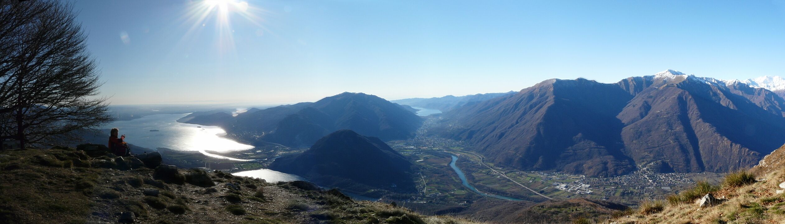 A mountainous landscape with a river, a town, and a clear sky.