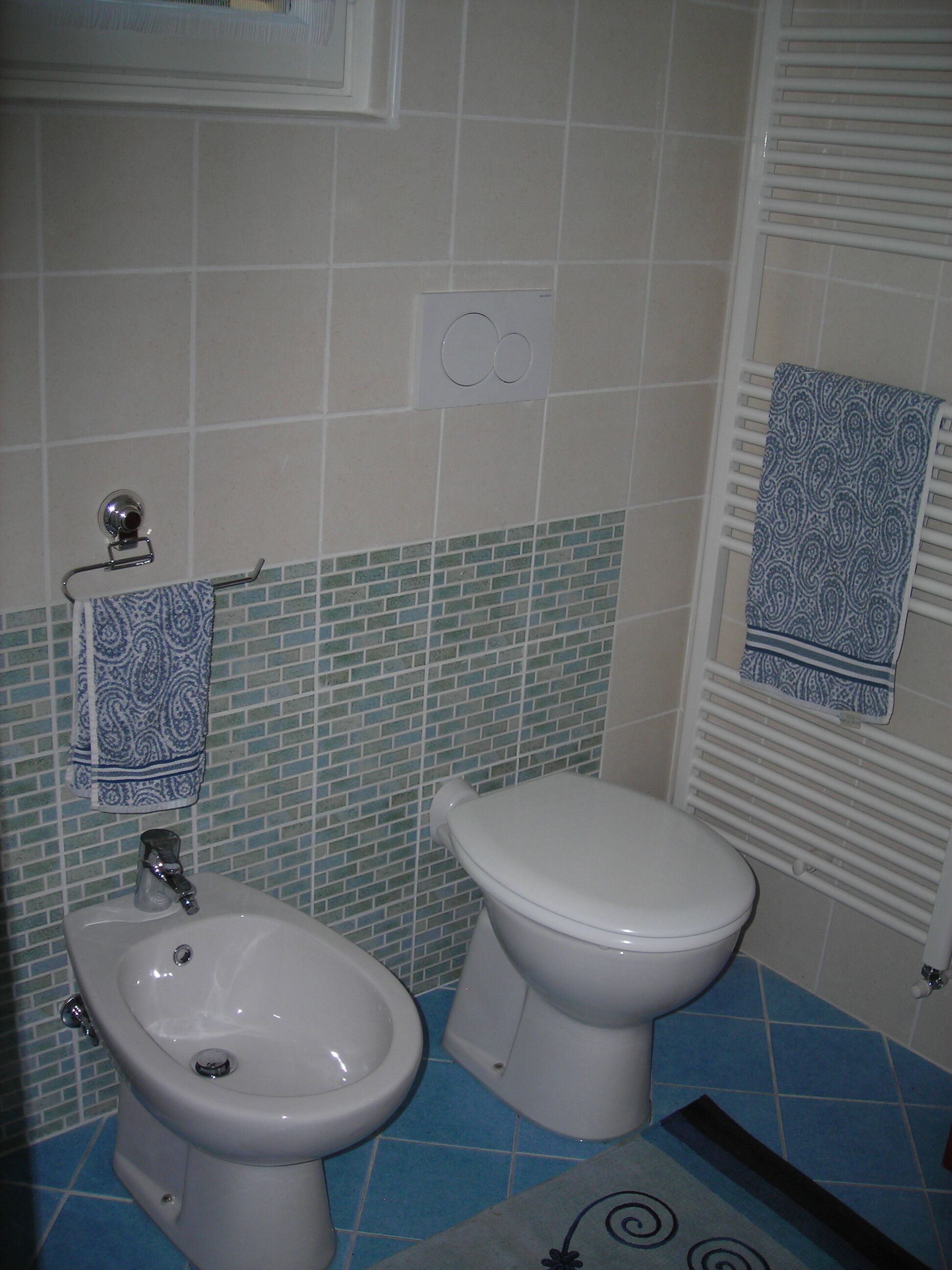 Une salle de bain équipée d’un bidet, de toilettes et d’un lavabo.