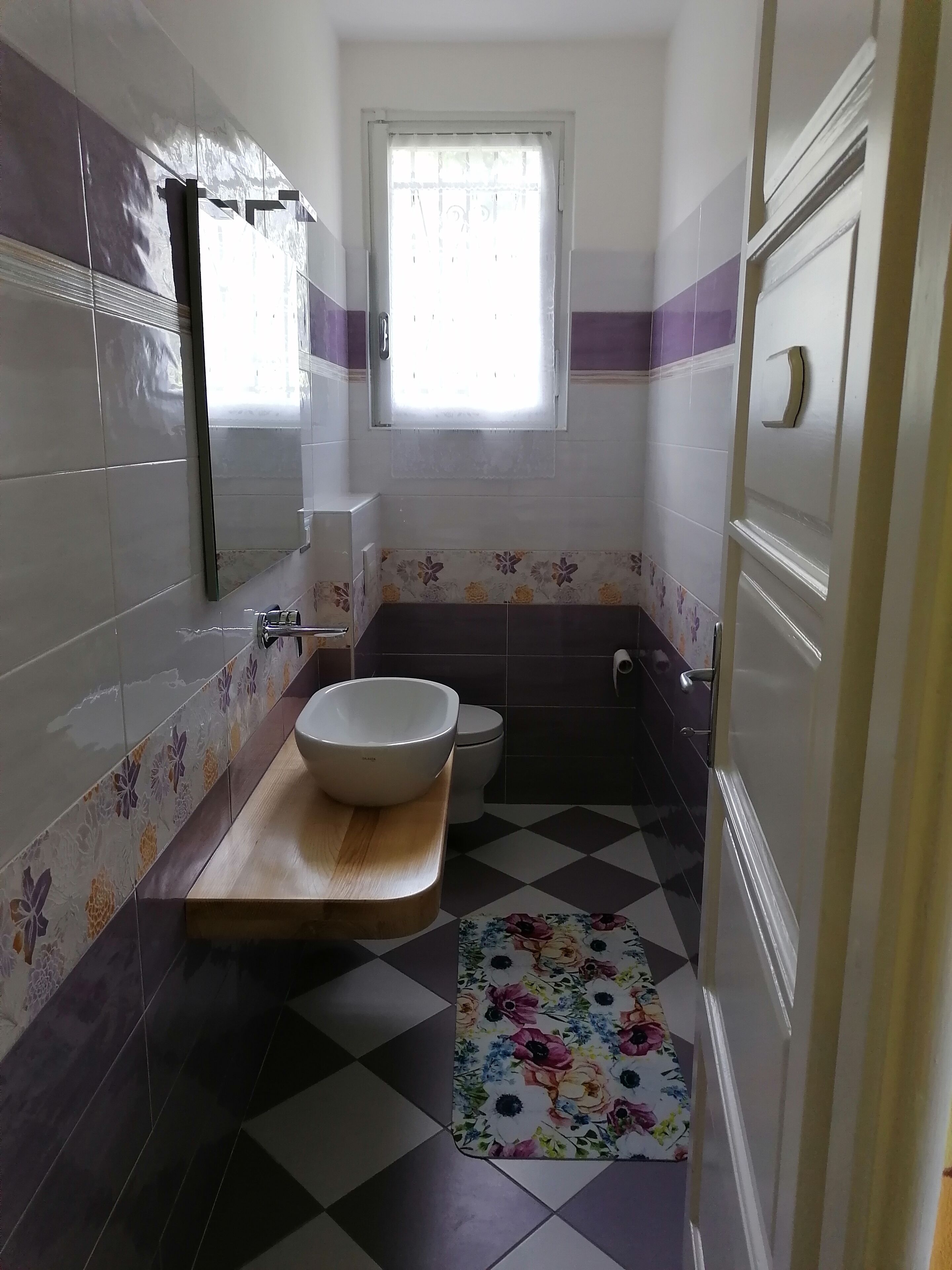 A bathroom with a wooden vanity, a white sink, a toilet, and a bathtub.