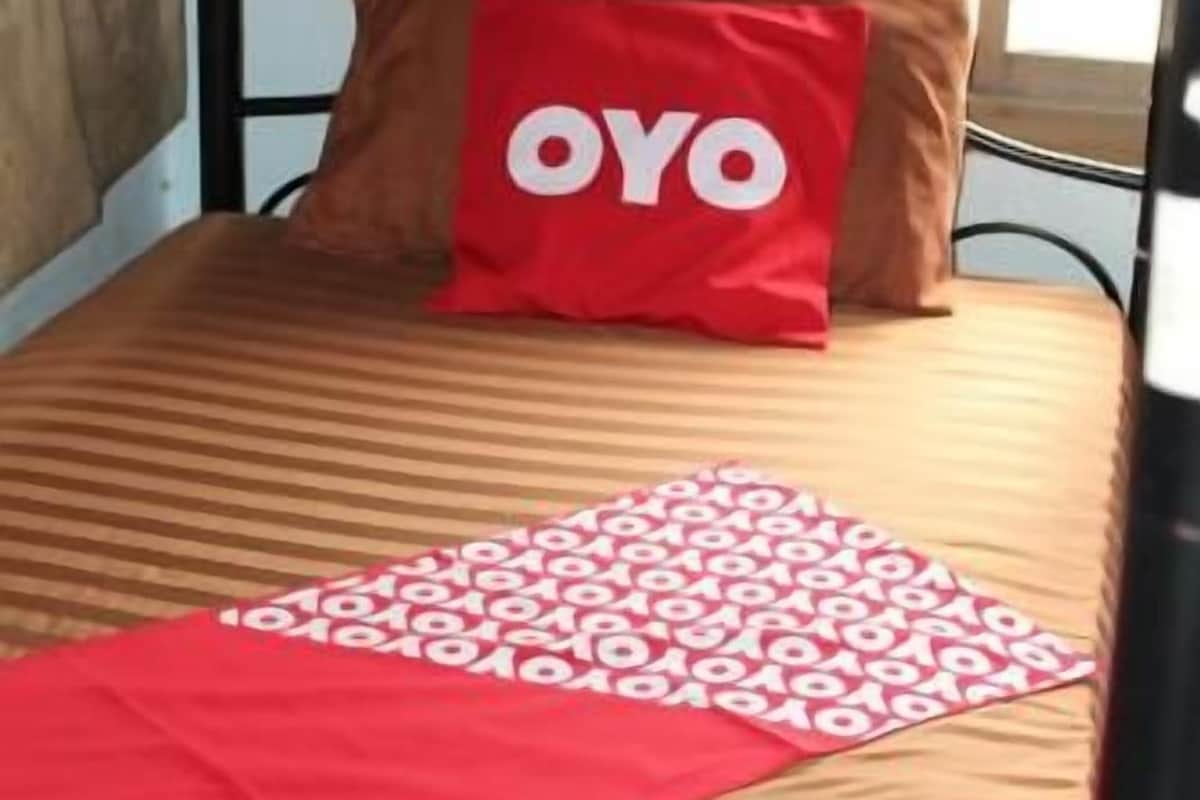Un lit superposé avec un oreiller rouge et une couverture à motifs.