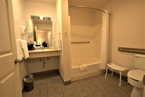 Een bad/douchecombinatie, een haardroger, handdoeken