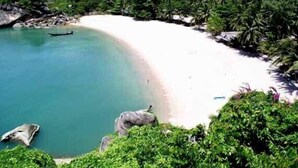 A beach with clear turquoise water, white sand, and lush greenery. - 4 bedroom pool villa (Koh Phangan)