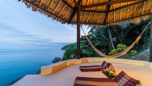 A beachside lounge with a thatched roof, cushioned seating, and a hammock. - 4 bedroom pool villa (Koh Phangan)