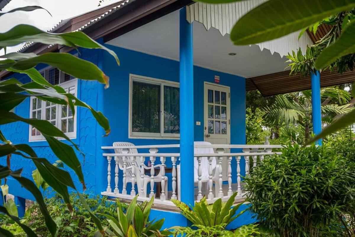 A blue building with white railings and a porch.