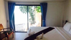 A hotel room with a bed, a chair, and a view of the outdoors. - Daetong Resort (Koh Samui)