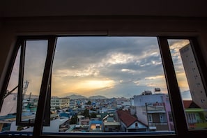 Vista de un paisaje urbano a través de una ventana, con varios edificios, incluido un hotel.