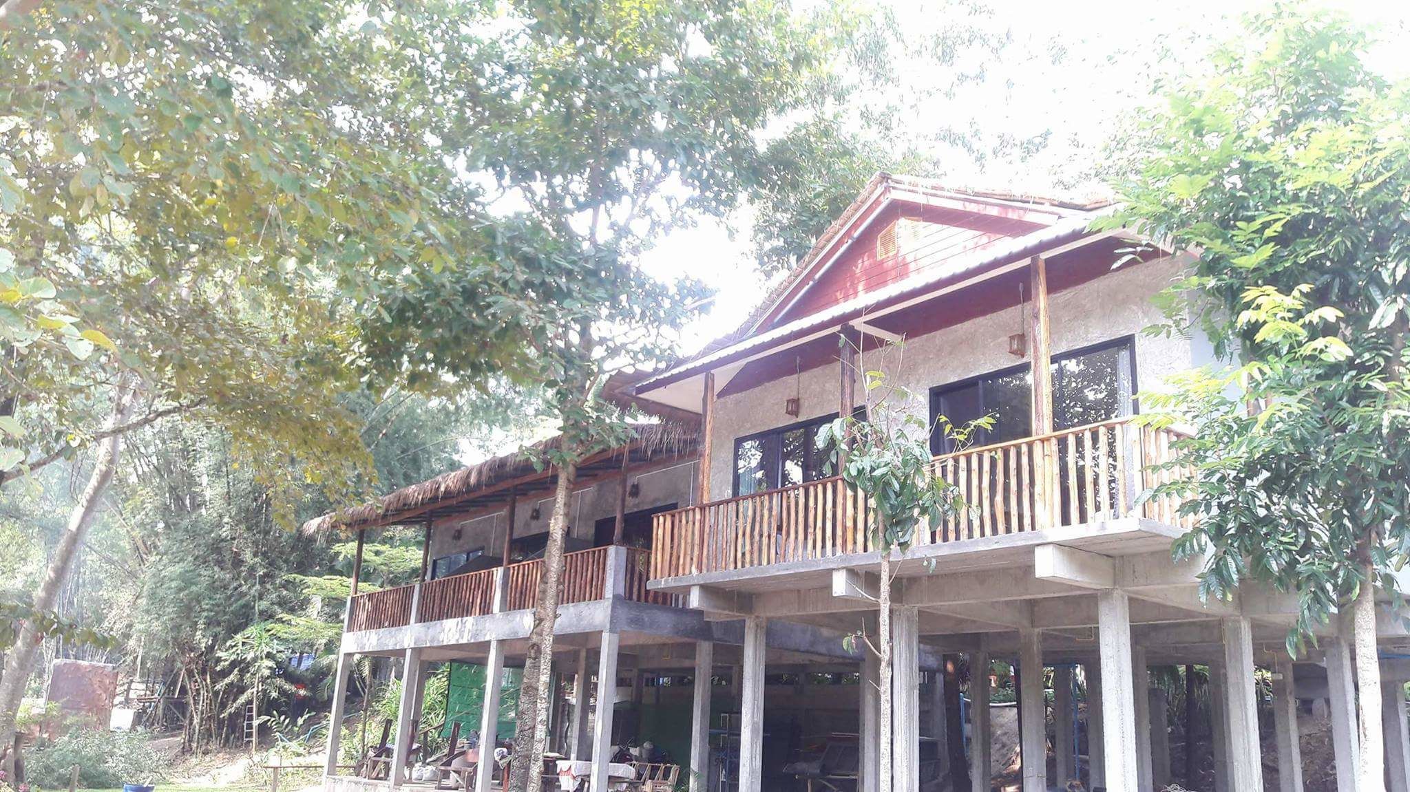 A two-story building with a wooden balcony and a thatched roof.