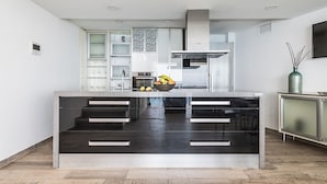 A modern kitchen with a central island, stainless steel appliances, and a minimalist design. - Villa Maiquetia, villa with heated swimming pool (Sta Úrsula)