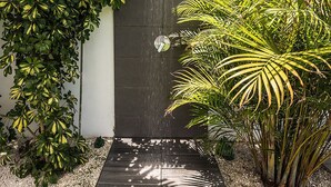 A modern outdoor area with a water feature, a wooden deck, and lush greenery. - Villa Maiquetia, villa with heated swimming pool (Sta Úrsula)