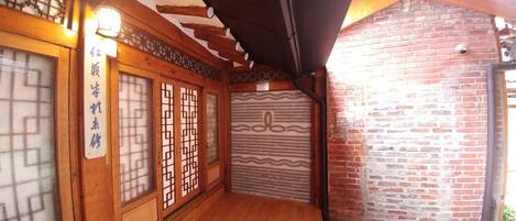Una habitación de madera tradicional con puertas correderas y una pared de ladrillo.