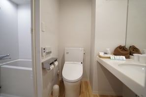 Een kleine, praktische badkamer met toilet, wastafel en spiegel.