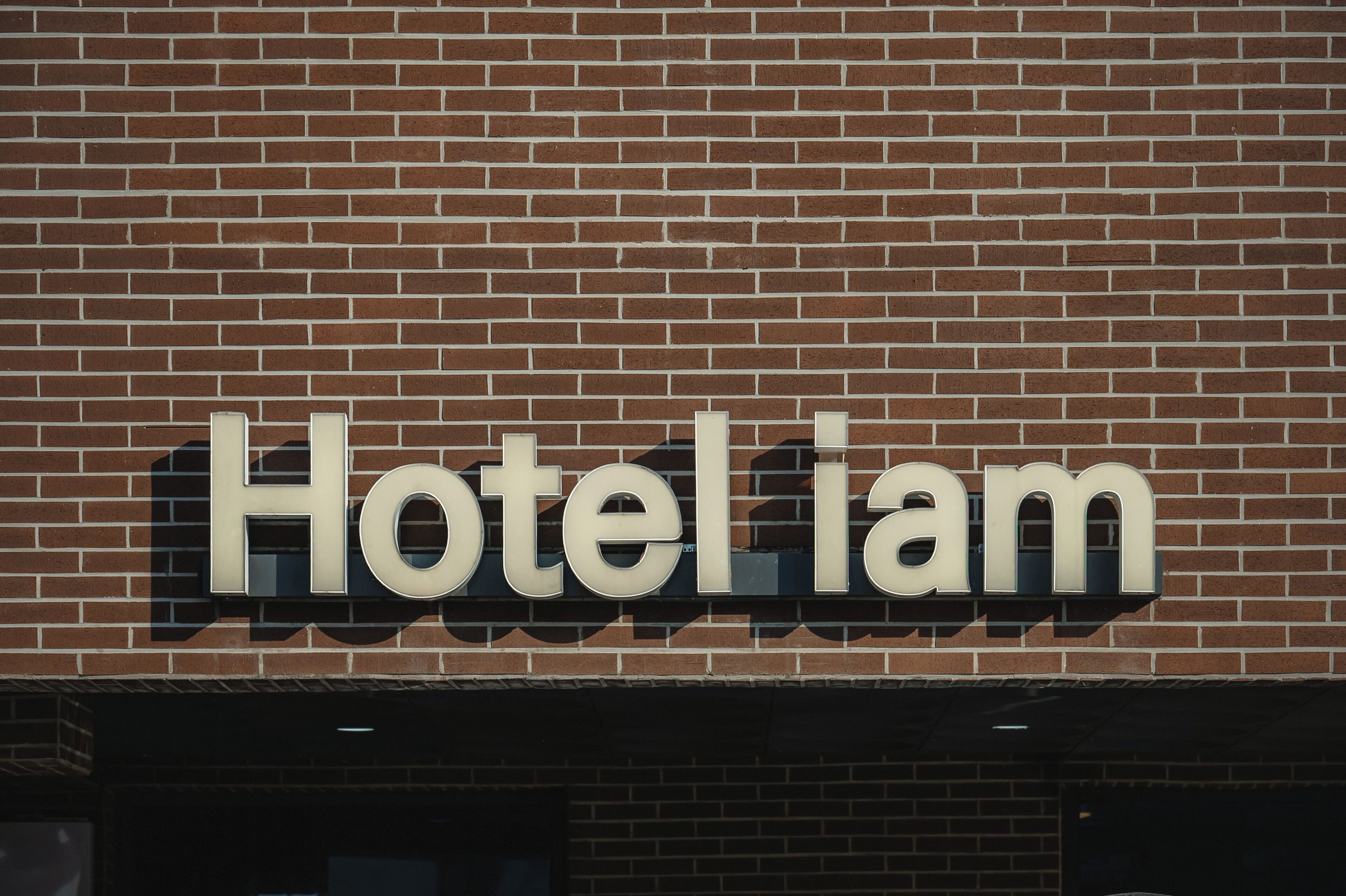 Pared de ladrillo con el letrero "Hotel Liam" que indica el nombre del hotel.