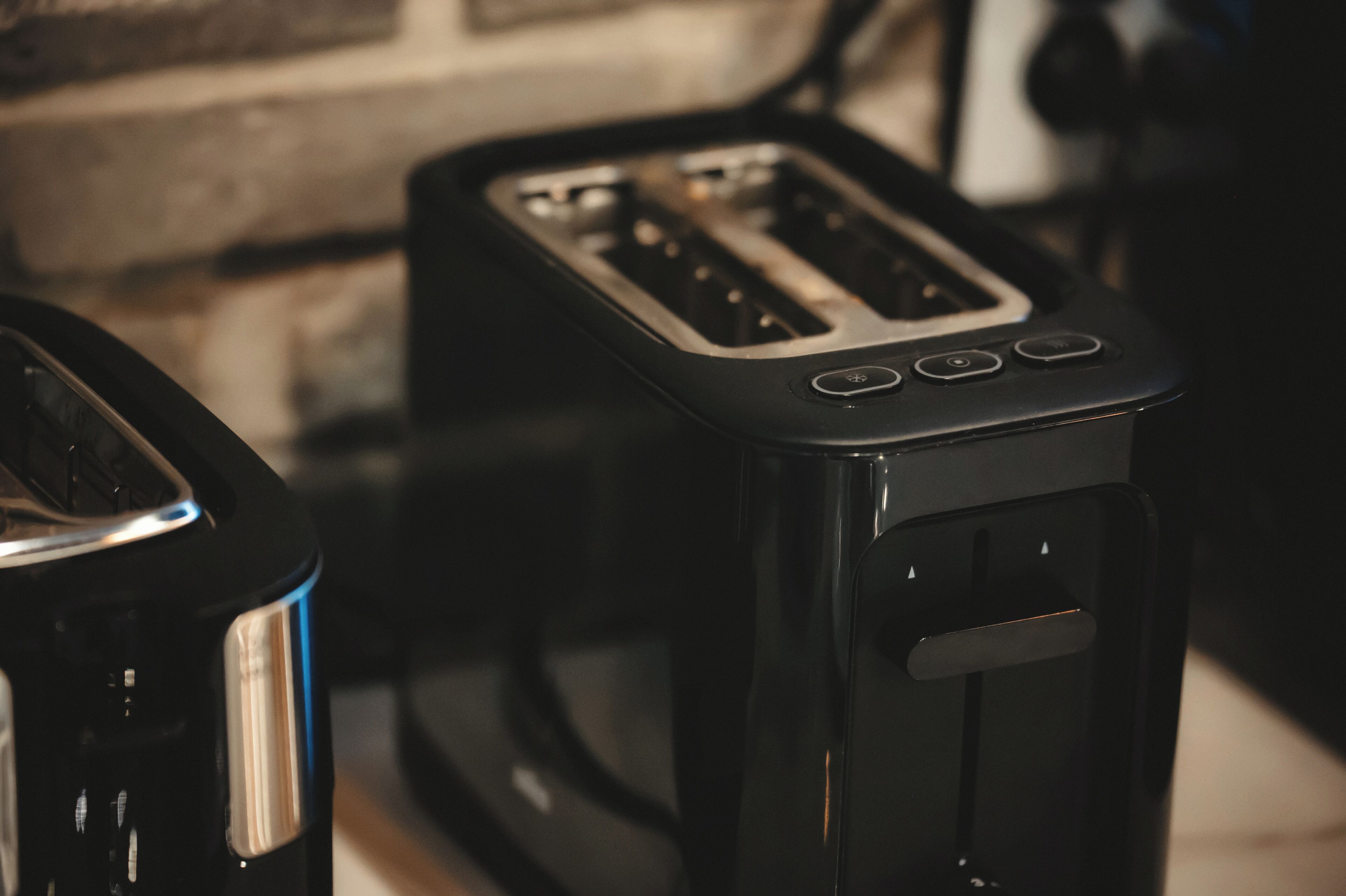 Un grille-pain noir à deux fentes, doté d’un panneau de commande avec des boutons.